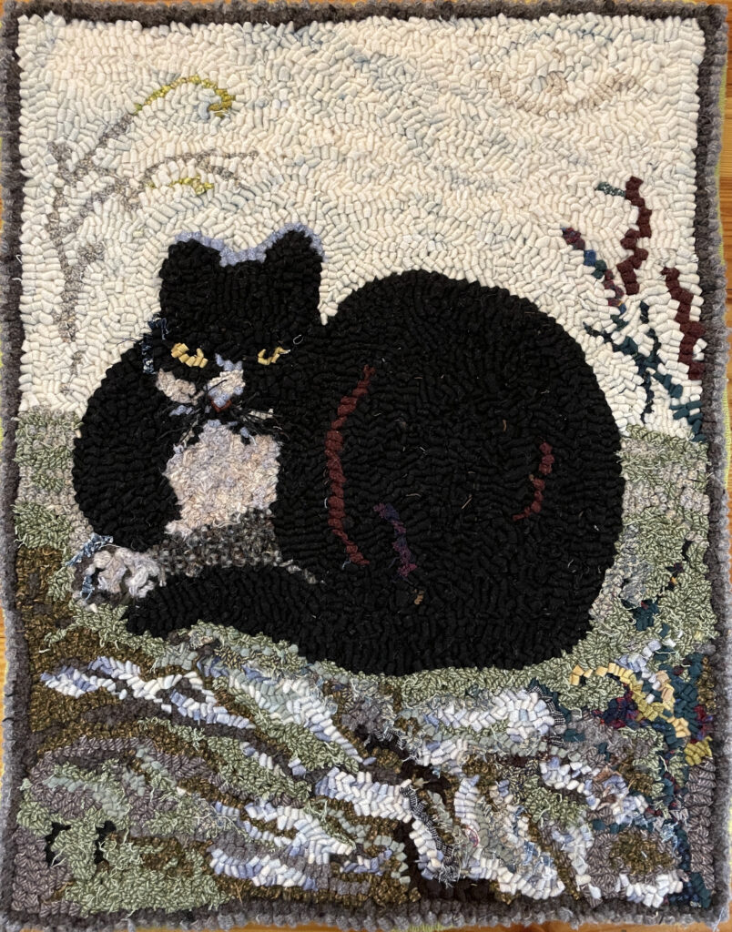 Hand-hooked Rug with a black house-cat curled up in the foreground.